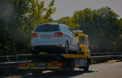 Carro prata sobre a plataforma de um guincho. Imagem ilustrativa.